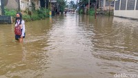 Tampak seorang siswa menerobos banjir saat pulang sekolah.