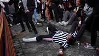 Seorang wasit terbaring di jalan saat pegulat Cholita tengah bertarung di tengah perayaan Electropreste yang digelar di kawasan La Paz, Bolivia.