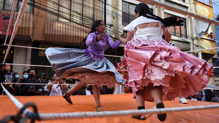 Penampilan para pegulat Cholita mencuri perhatian di perayaan Electropreste, Bolivia. Dalam aksinya, mereka bergulat dengan mengenakan pakaian tradisional.