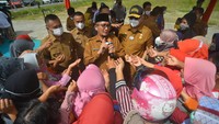 Wali Kota Padang, Hendri Septa (tengah) membagikan voucher potongan harga minyak goreng kepada warga saat Pasar Murah di halaman Balaikota Padang, Sumatera Barat, Senin (14/3/2022). Pemkot Padang bekerja sama dengan produsen minyak goreng menyiapkan 6.000 bungkus (isi dua liter) minyak goreng kemasan yang dijual Rp 14 ribu per liter. (ANTARA FOTO/Iggoy el Fitra).