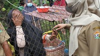 Tampak seorang ibu menangis di balik pagar besi akibat tidak mendapatkan kartu antrean minyak goreng di operasi pasar murah yang digelar Dinas Perindustrian dan Perdagangan Sulawesi Tenggara di Kendari, Sulawesi Tenggara. (ANTARA FOTO/Jojon).