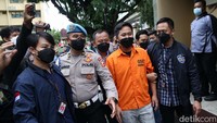 Doni Salmanan tampak digiring polisi saat akan jumpa pers. Terlihat tangannya tidak diborgol namun petugas memegang sisi kiri dan kanan.