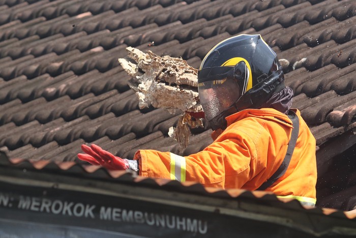 EVAKUASI SARANG TAWON VESPA Petugas pemadam kebakaran mengevakuasi sarang tawon vespa di rumah warga di Kelurahan Mrican, Kota Kediri, Jawa Timur, Senin (14/3/2022). Petugas pemadam kebakaran daerah setempat rata-rata mengevakuasi satu sarang tawon vespa atau tawon ndas per hari di kawasan permukiman karena meresahkan dan membahayan warga. ANTARA FOTO/Prasetia Fauzani/rwa.