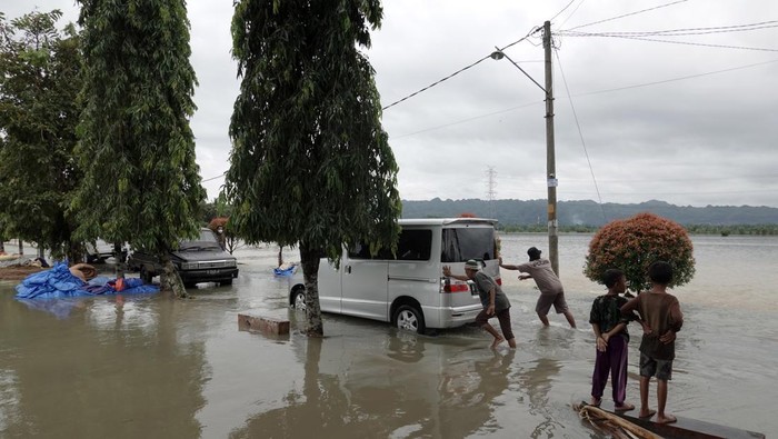 Sejumlah warga mendorong mobil yang terjebak banjir di Desa Gebangsari, Tambak, Banyumas, Jawa Tengah, Selasa (15/3/2022). Hingga saat ini tercatat delapan desa yang tersebar pada dua kecamatan di Kabupaten Banyumas, Jawa Tengah terendam banjir dan sejumlah lokasi lainnya dilanda longsor, akibat hujan lebat yang menyebabkan bencana hidrometeorologi di wilayah selatan Jawa Tengah. ANTARA FOTO/Idhad Zakaria/wsj.