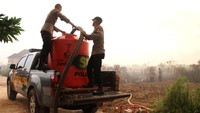Personil kepolisian menyedot air dari tangki untuk memadamkan kebakaran hutan dan lahan di Jalan Aloe Vera, Pontianak Selatan, Kalimantan Barat. Minimnya sumber air di lokasi karhutla menyulitkan petugas gabungan untuk melakukan pemadaman hingga harus mengambil air menggunakan tangki penampungan air dari tempat lain.