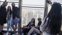 Pengunjung berfoto dengan latar belakang Kota Dubai di atas gedung Burj Khalifa.