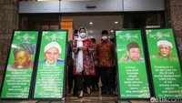 Dia tampak mengenakan kerudung putih dan kebaya merah.