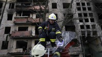 Tampak petugas pemadam kebakaran memegang sebuah foto yang ditemukan di puing-puing sebuah bangunan yang terdampak serangan di Kyiv, ibu kota Ukraina. AP Photo/Vadim Ghirda
