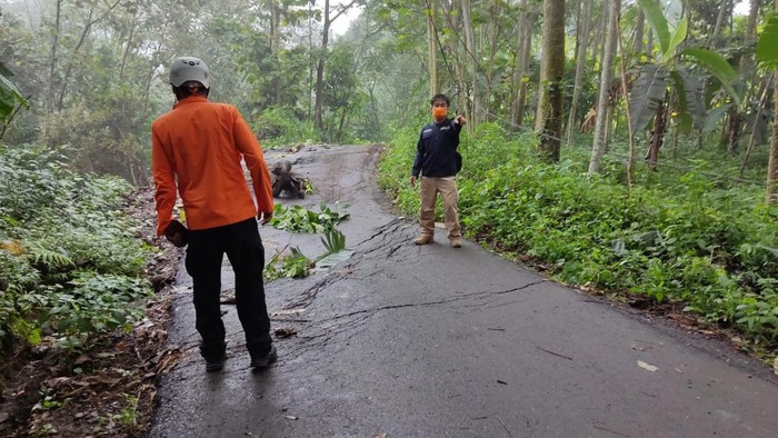 Petugas memeriksa jalan ambles di Sumedang.