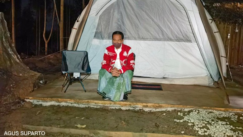 Potret Jokowi Sarungan saat Bermalam di IKN Nusantara Presiden Joko Widodo (kanan) mengenaan sarung berwarna hijau dan jaket merah bertuliskan G20 saat bermalam di titik nol Ibu Kota Negara (IKN) Nusantara, Kecamatan Sepaku, Penajam Paser Utara, Kalimantan Timur, Senin (14/3/2022). Presiden bersama sejumlah menteri dan lima gubernur di Pulau Kalimantan bermalam di lokasi titik nol IKN Nusantara.