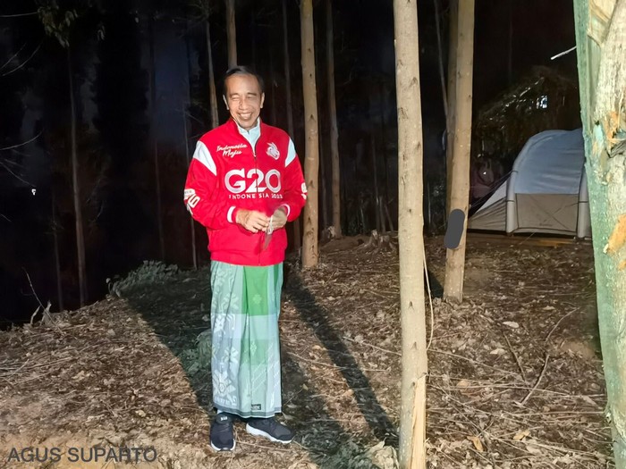 Potret Jokowi Sarungan saat Bermalam di IKN Nusantara Presiden Joko Widodo (kanan) mengenaan sarung berwarna hijau dan jaket merah bertuliskan G20 saat bermalam di titik nol Ibu Kota Negara (IKN) Nusantara, Kecamatan Sepaku, Penajam Paser Utara, Kalimantan Timur, Senin (14/3/2022). Presiden bersama sejumlah menteri dan lima gubernur di Pulau Kalimantan bermalam di lokasi titik nol IKN Nusantara.