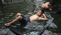 Dengan papan karet, anak ini tampak duduk santai.