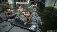 Seorang anak tampak berenang di air banjir yang merendam kawasan Duren Sawit, Jakarta Timur, Selasa (15/3/2022).