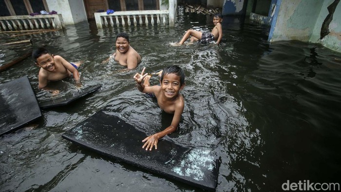 Banjir di Duren Sawit, Jakarta Timur, telah terjadi hampir sepekan. Banjir ini jadi tempat bermain anak-anak.