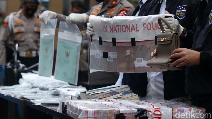Polisi menyita sejumlah barang bukti dari tersangka Doni Salmanan terkait aplikasi trading Quotex. Ada mobil mewah hingga uang bertumpuk-tumpuk.