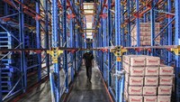 Seorang pegawai melintas di antara rak penyimpanan kardus yang berisikan minyak goreng merk Bimoli yang akan didistribusikan dari gudang PT Salim Ivomas Pratama di Tanjung Priok, Jakarta, Selasa (15/3/2022).