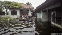 Warga beraktivitas di Kelurahan Pondok Bambu, Duren Sawit, Jakarta Timur, yang terendam banjir, Selasa (15/3/2022).