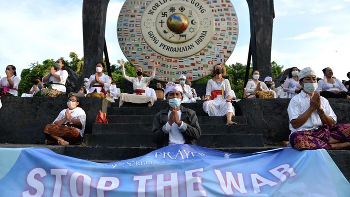 Warga Bali dan WNA Gelar Doa Bersama untuk Perdamaian Dunia Sejumlah warga negara asing bersama warga lainnya membentangkan spanduk saat kegiatan doa untuk perdamaian dunia di Gong Perdamaian Dunia, Kertalangu, Denpasar Senin (14/3/2022). Kegiatan doa bersama lintas agama tersebut dilakukan untuk memohon terciptanya perdamaian di dunia serta mendoakan agar operasi militer Rusia terhadap Ukraina dapat segera dihentikan. ANTARA FOTO/Fikri Yusuf/rwa.