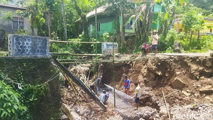 Warga bergerak membangun jembatan di Desa Ramea, Pandeglang yang ambrol akibat banjir. Jembatan itu terputus akibat banjir dan hujan lebat. (Aris Rivaldo/detikcom)