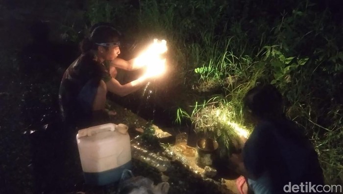Warga mengambil tumpahan minyak dari pipa distribusi di Blora yang bocor, Selasa (15/3/2022).