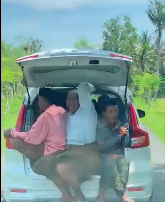 3 pria terlihat duduk di bagasi Suzuki Ertiga dengan pintu terbuka