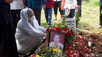 Tatapan mata April Jasmine terlihat sangat sendu dan masih berkaca-kaca di depan makam sang ayah. Foto: Hanif/detikHOT