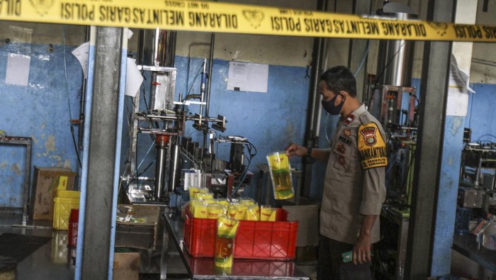Gudang Minyak Goreng di Depok Disegel Polisi Polisi mengecek gudang pengemasan yang dipasang garis polisi di Jalan Pasir Putih, Depok, Jawa Barat, Rabu (16/3/2022). Kasat Reskrim Polres Metro Depok AKBP Yogen Heroes Baruno mengatakan gudang tersebut tidak memiliki izin usaha dari Dinas Perindustrian dan Perdagangan (Disperindag) dan tidak mengantongi label POM dari Dinas Kesehatan serta diduga melakukan penyelewengan pendistribusian minyak goreng merek tertentu dengan cara mengemas ulang . ANTARA FOTO/Asprilla Dwi Adha/tom.