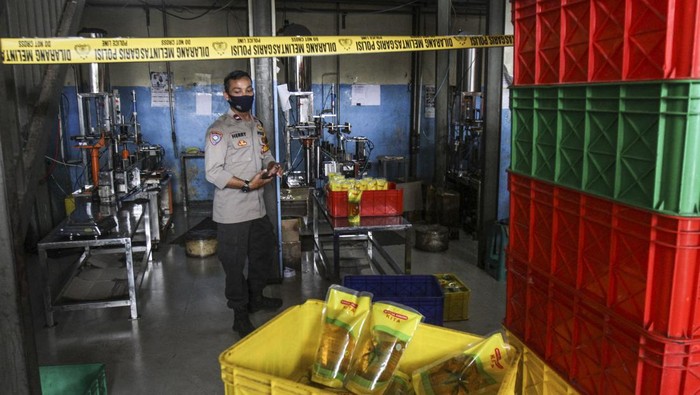 Gudang Minyak Goreng di Depok Disegel Polisi Polisi mengecek gudang pengemasan yang dipasang garis polisi di Jalan Pasir Putih, Depok, Jawa Barat, Rabu (16/3/2022). Kasat Reskrim Polres Metro Depok AKBP Yogen Heroes Baruno mengatakan gudang tersebut tidak memiliki izin usaha dari Dinas Perindustrian dan Perdagangan (Disperindag) dan tidak mengantongi label POM dari Dinas Kesehatan serta diduga melakukan penyelewengan pendistribusian minyak goreng merek tertentu dengan cara mengemas ulang . ANTARA FOTO/Asprilla Dwi Adha/tom.