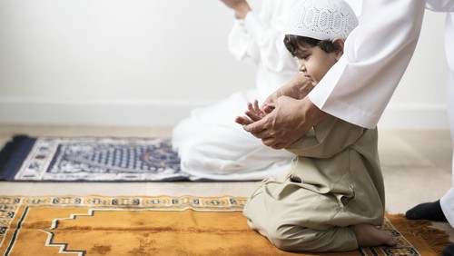 Muslim boy learning how to make Dua to Allah