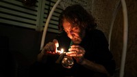 Seorang pelanggan merokok dari bong di kafe ganja medis di Tira.