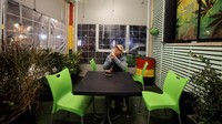 Seorang pelanggan merokok di kafe ganja medis di Tira.