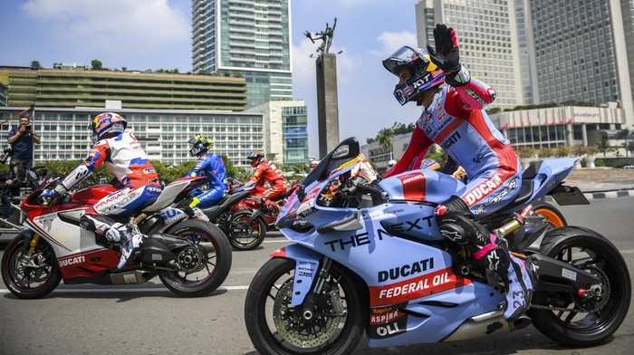 Warga memotret pembalap motoGP usai mengikuti parade di kawasan Bundaran HI, Jakarta, Rabu (16/3/2022). Parade tersebut untuk memeriahkan pagelaran MotoGP seri kedua Pertamina Grand Prix of Indonesia di Pertamina Mandalika International Street Circuit pada 18 - 20 Maret 2022. ANTARA FOTO/Galih Pradipta/tom.