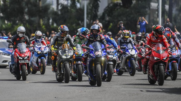 Warga memotret pembalap motoGP usai mengikuti parade di kawasan Bundaran HI, Jakarta, Rabu (16/3/2022). Parade tersebut untuk memeriahkan pagelaran MotoGP seri kedua Pertamina Grand Prix of Indonesia di Pertamina Mandalika International Street Circuit pada 18 - 20 Maret 2022. ANTARA FOTO/Galih Pradipta/tom.