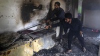 Warga Khasmir membersihkan puing-puing di dalam sebuah rumah yang menjadi lokasi baku tembak, Rabu, (16/3/2022).