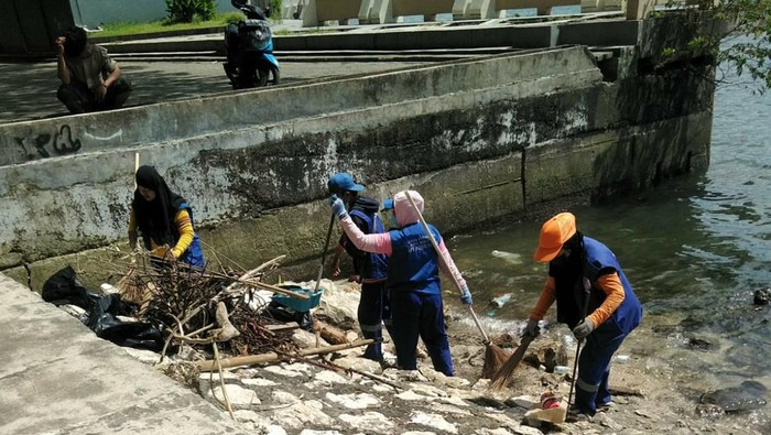 Petugas UPT Losari Makassar membersihkan sampah di pesisir pantai.