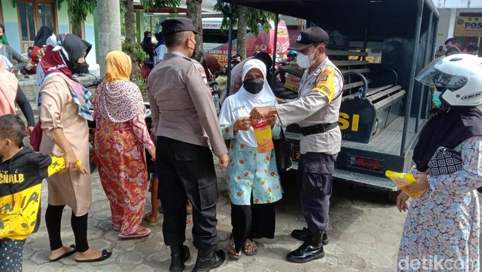 Polisi memberikan minyak goreng kepada warga Magetan yang sudah mengikuti vaksinasi