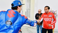 Jokowi dan para pebalap MotoGP tampak berbincang dengan Jokowi. Sesekali mereka tertawa ringan.  
