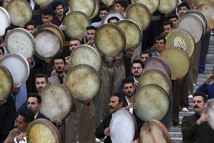 Musicians from the Kurdish western region of Iran play Daf, a hand-held Persian drum, in a ceremony ahead of the Iranian New Year, or Nowruz, at a park in Tehran, Iran, Monday, March 14, 2022. Nowruz dates back to at least 1700 B.C. and in ancient Zoroastrian traditions is the most important and anticipated holiday in Iranian culture and has been widely celebrated through various times and eras across the territories of the old Persian empire, from the Mideast to Central Asia. (AP Photo/Vahid Salemi)