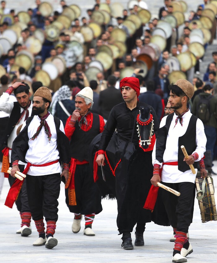 Musicians from the Kurdish western region of Iran play Daf, a hand-held Persian drum, in a ceremony ahead of the Iranian New Year, or Nowruz, at a park in Tehran, Iran, Monday, March 14, 2022. Nowruz dates back to at least 1700 B.C. and in ancient Zoroastrian traditions is the most important and anticipated holiday in Iranian culture and has been widely celebrated through various times and eras across the territories of the old Persian empire, from the Mideast to Central Asia. (AP Photo/Vahid Salemi)