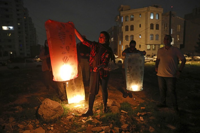 Tahun Baru Persia People light wish lanterns while celebrating Chaharshanbe Souri, or Wednesday Feast, an ancient Festival of Fire, on the eve of the last Wednesday of the solar Persian year, in Tehran, Iran, Tuesday, March 15, 2022. While approaching the Iranian New Year, people across the country, light bonfires, set off fireworks sending wish lanterns into the night sky during the annual ritual that dates back to at least 1700 B.C. and is linked to Zoroastrianism in the Persian Empire. (AP Photo/Vahid Salemi)