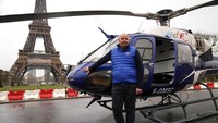Pilot helikopter Franck Charlet berpose ke wartawan setelah sukses mengangkut menara telekomunikasi ke puncak Eiffel.