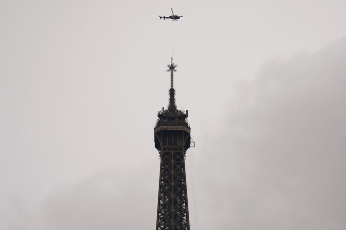 A Eurocopter Ecureuil 2 helicopter installs a new telecom transmission TDF (TeleDiffusion de France) antenna on the top of the Eiffel Tower in Paris, France, Tuesday, March 15, 2022. The six meters antenna is raising the Eiffel Tower from 324 meters to 330 meters.(AP Photo/Francois Mori)