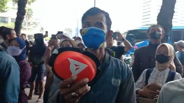 Warga bernama Ari mendapatkan knee slider pebalap MotoGP Jack Miller di depan Hotel Kempinski, Rabu (16/3/2022)