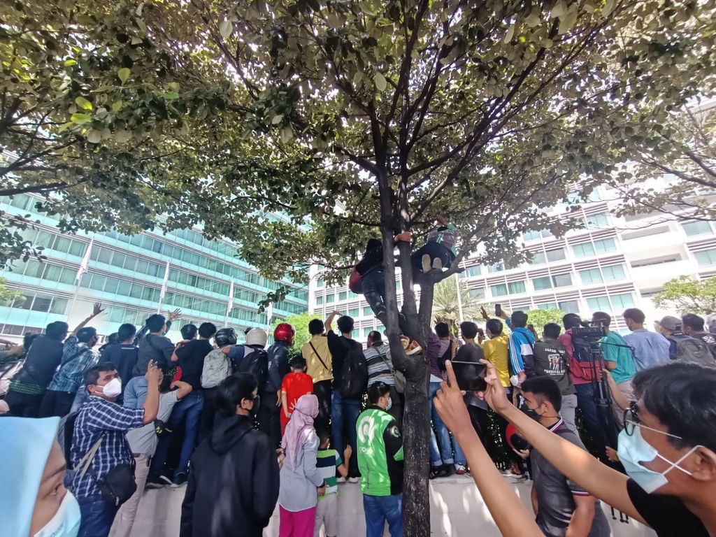 Warga memanjat pohon hingga naik pagar Hotel Kempinski demi mengabadikan foto pebalap MotoGP, Rabu (16/3/2022).