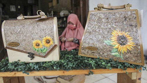 Perajin menyelesaikan pembuatan tas dari limbah triplek di Mienani Craft, Depok, Jawa Barat, Kamis (17/3/2022). Tas berbahan dasar dari limbah triplek, kayu, dan pelepah pisang tersebut dijual dengan harga Rp500 ribu hingga Rp1 juta per tas tergantung tingkal kesulitan serta dipasarkan melalui media sosial. ANTARA FOTO/Asprilla Dwi Adha/hp.