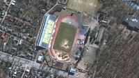 Kerusakan merata terlihat dari citra satelit Maxar. Tampak sebuah stadion berlubang oleh rudal Rusia.  