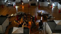 Namun tak sedikit warga yang memutuskan untuk mengungsi karena khawatir munculnya gempa susulan. Posko pengungsian sementara itu salah satunya berada di kawasan Soma, Prefektur Fukushima. Tampak sejumlah warga masih berada di area gimnasium yang dialihfungsikan menjadi pengungsian sementara, Kamis (17/3/2022). Kyodo News via AP.
