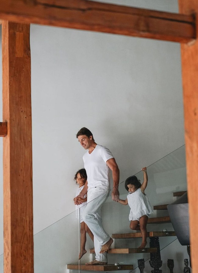 Suami Indah Kalalo pun tampak begitu dekat dengan anak-anaknya. Seperti yang terlihat dalam foto yang satu ini, Ibrahim Justin tampak dengan penuh kasih sayang menggandeng kedua anaknya menuruni tangga. Foto: dok. Instagram/@indahkalalo