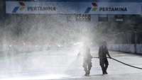 Petugas menyiramkan air ke lintasan Pertamina Mandalika International Street Circuit, di Lombok Tengah, NTB, Kamis (17/3/2022).