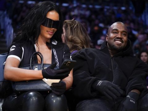 Entertainer Kanye West, right, watches the first half of an NBA basketball game between the Washington Wizards and the Los Angeles Lakers in Los Angeles, Friday, March 11, 2022. (AP Photo/Ashley Landis)